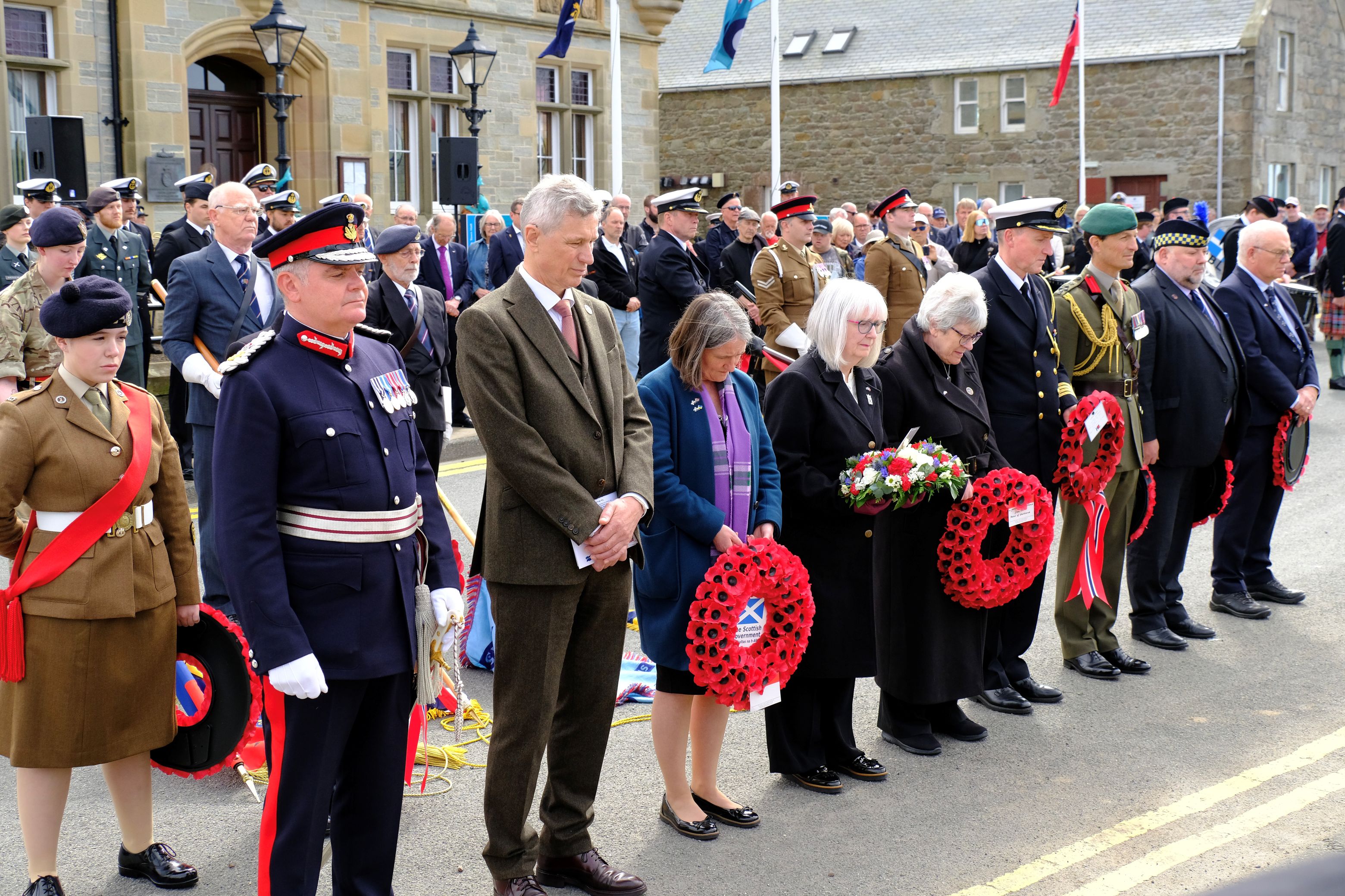 Wreath bearers line up before the memorial