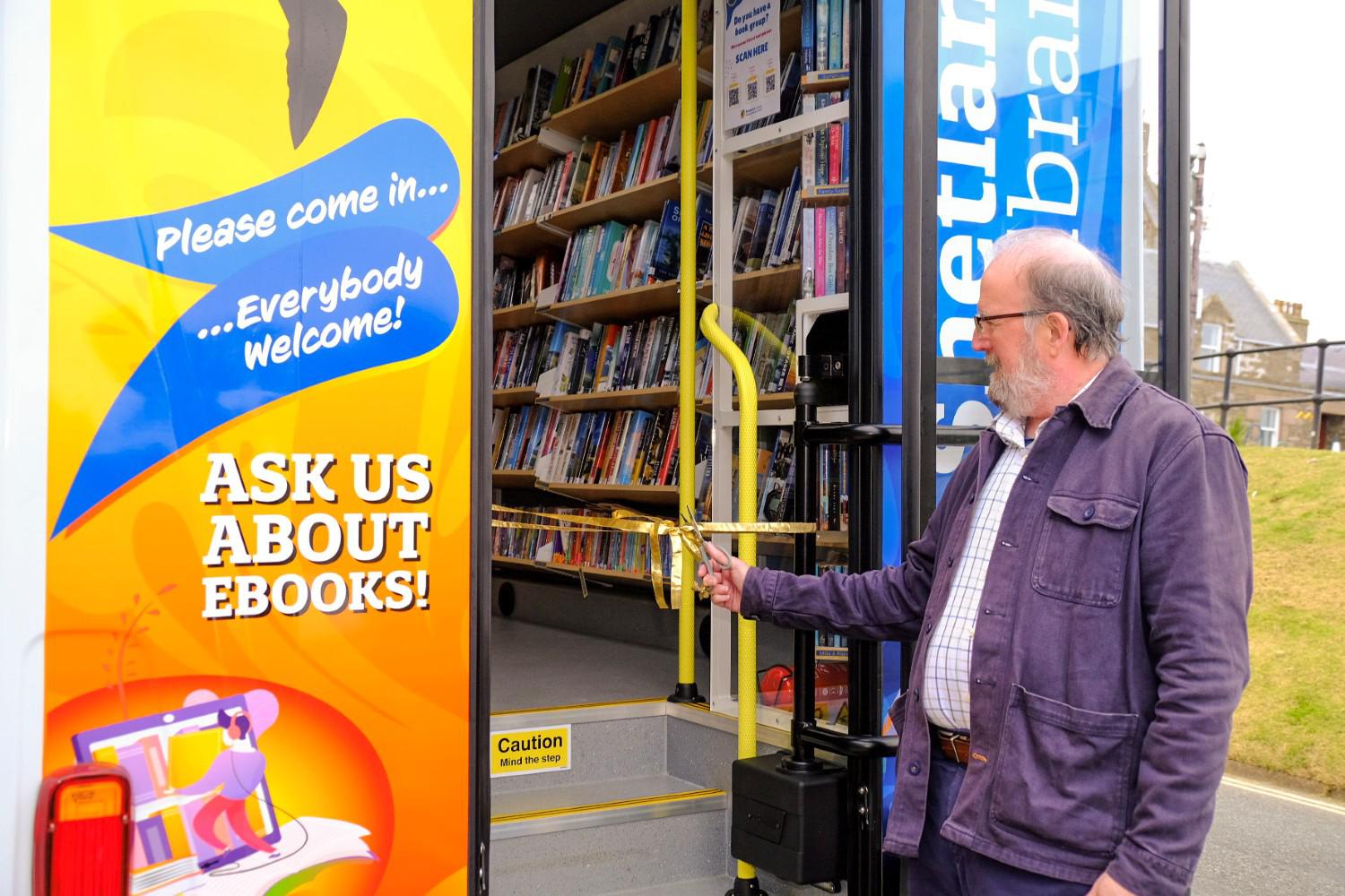 Councillor Davie Sandison cuts the ribbon on the new mobile library van.