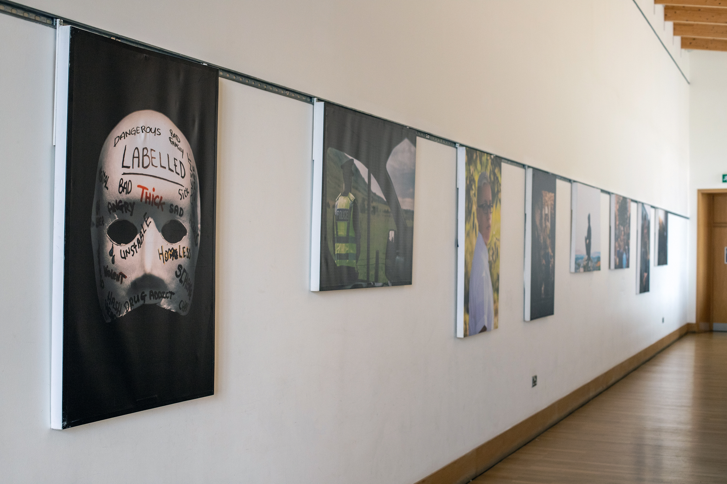 Canvasses from the Second Chancers exhibition, featuring images about the power of community justice hang on the wall in the upper cafe bar at Mareel