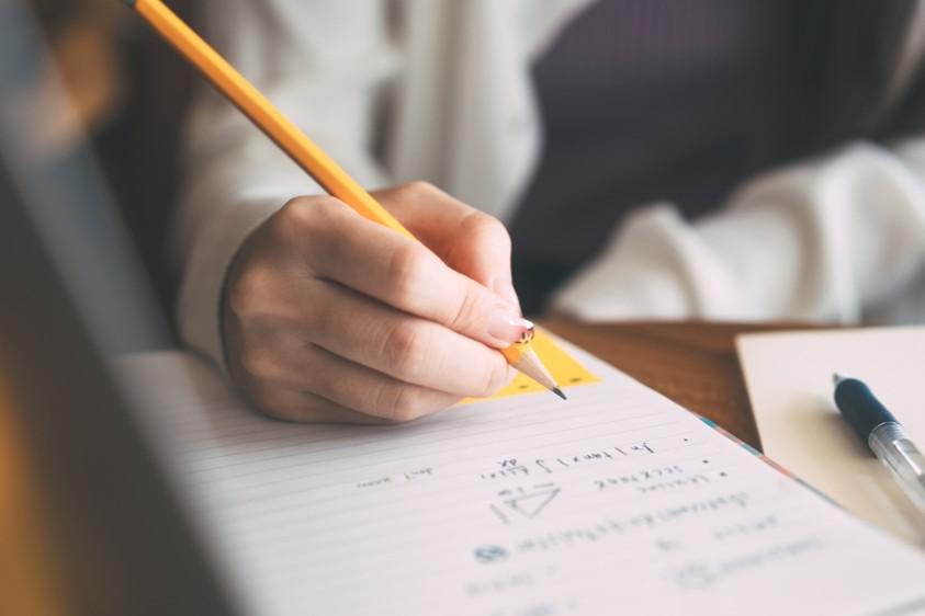 Hand writing on a notebook as if in an exam